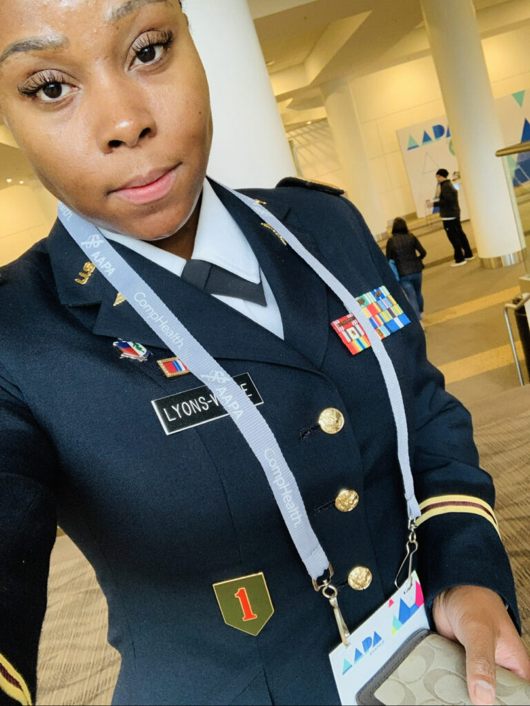 Tracey standing in military dress uniform at a conference